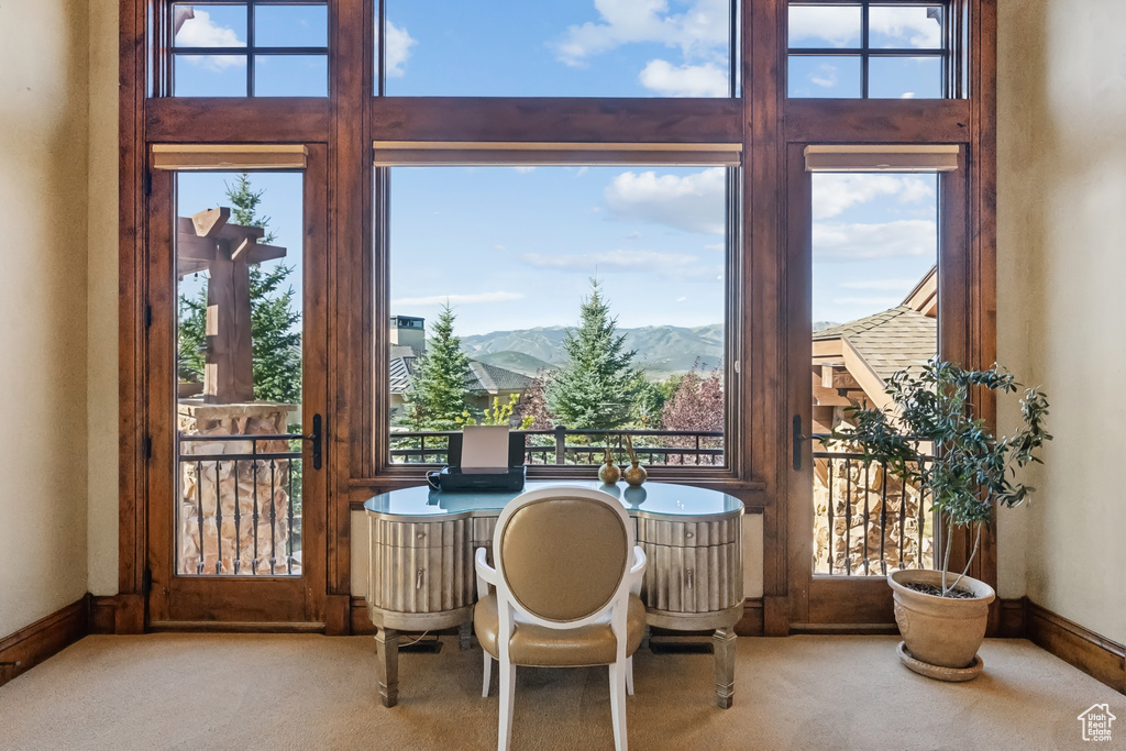 Carpeted dining room featuring a mountain view and baseboards