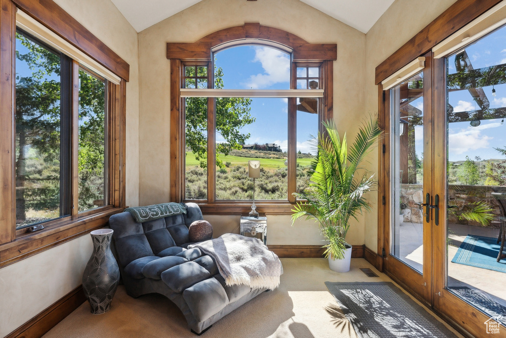 Sunroom with vaulted ceiling, plenty of natural light, french doors, and baseboards