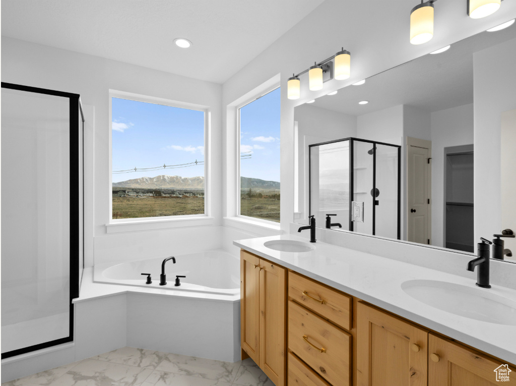 Full bath featuring marble finish floors, a shower stall, a garden tub, double vanity, and recessed lighting