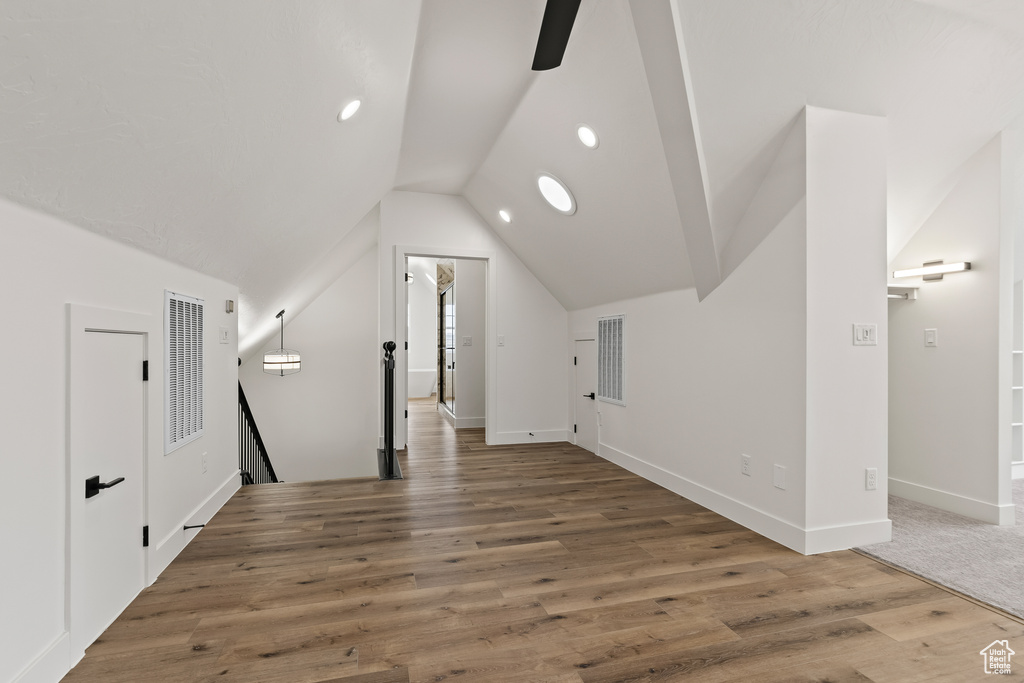 Bonus room featuring ceiling fan, hardwood / wood-style floors, and lofted ceiling