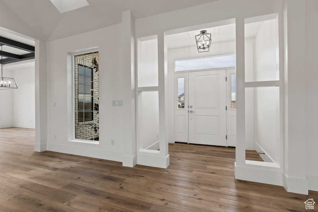 Foyer entrance featuring an inviting chandelier and hardwood / wood-style flooring