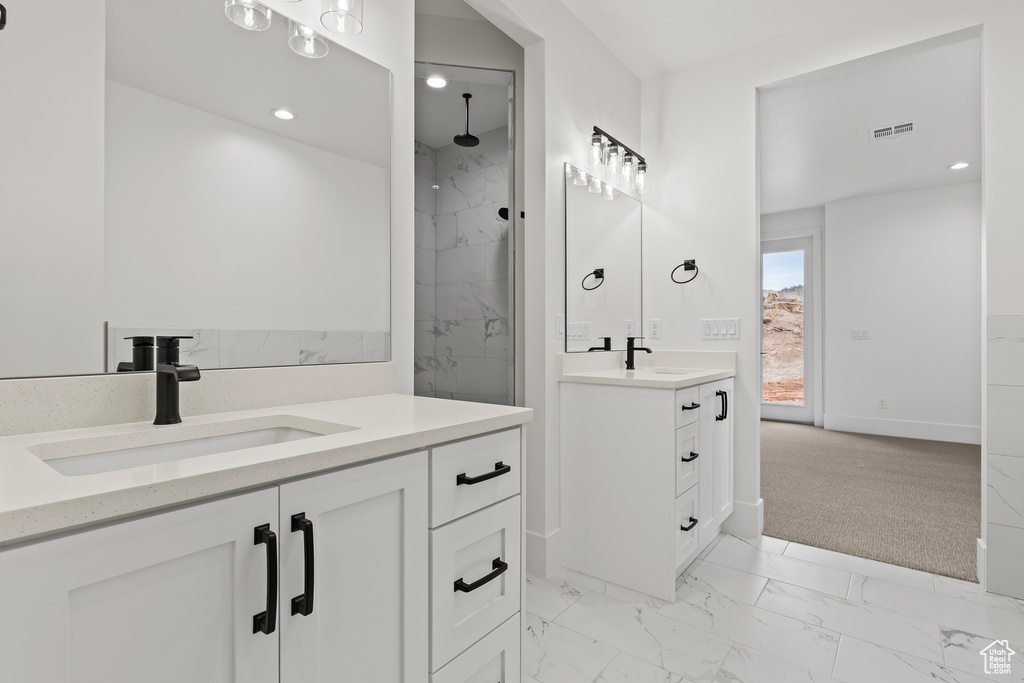 Bathroom featuring a tile shower and vanity