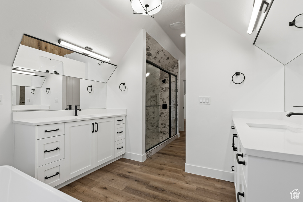 Bathroom with vanity, an enclosed shower, and hardwood / wood-style flooring