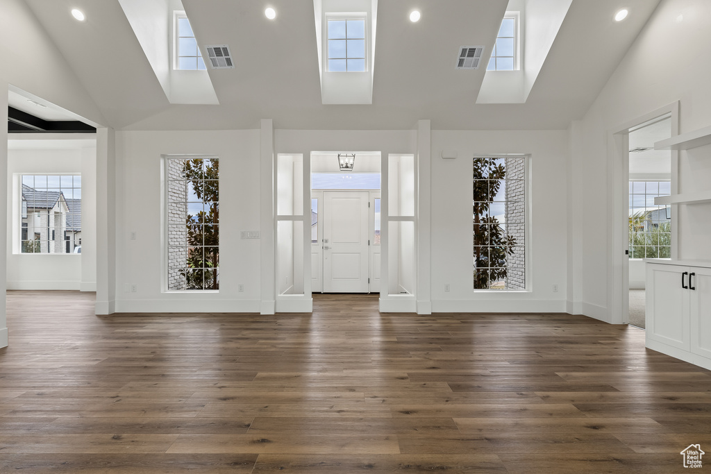 Entrance foyer with high vaulted ceiling and dark hardwood / wood-style floors