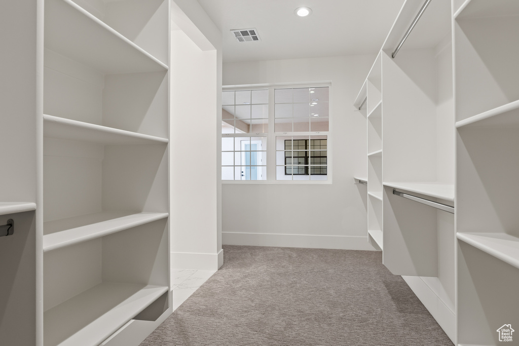 Walk in closet featuring light carpet