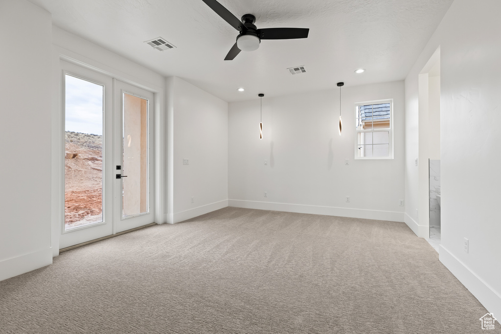 Unfurnished room featuring light carpet, french doors, and ceiling fan