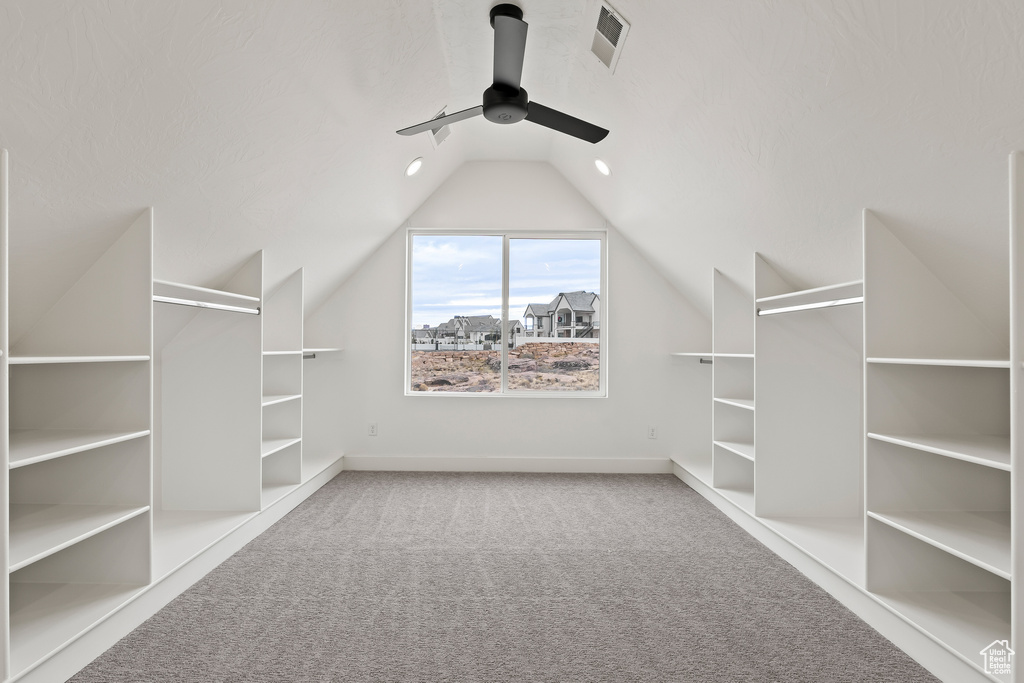 Spacious closet featuring carpet, ceiling fan, and lofted ceiling