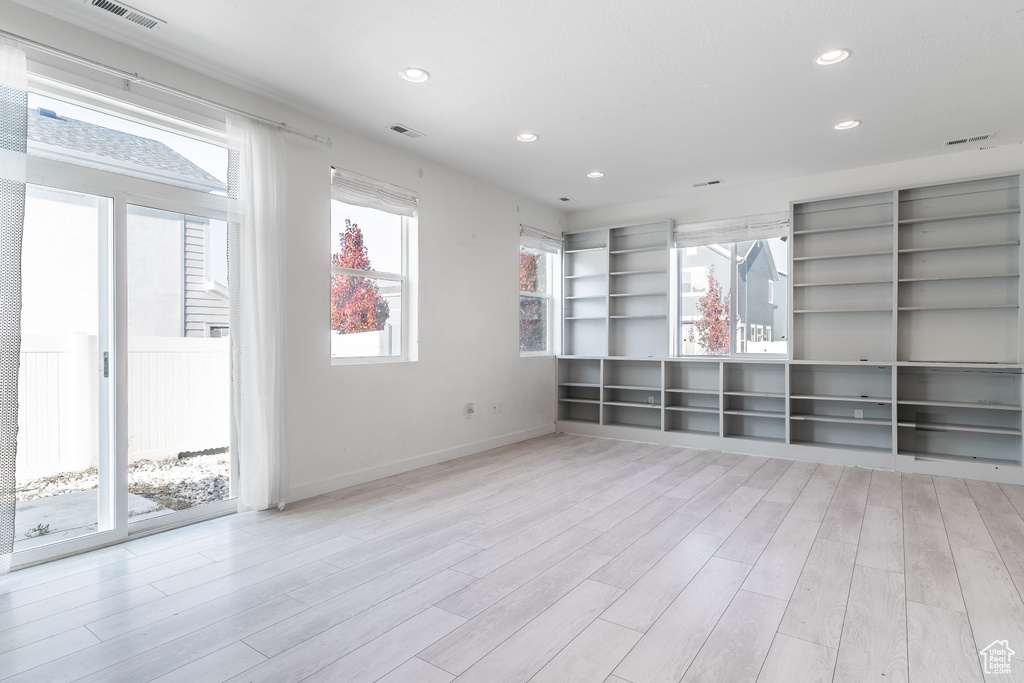 Spare room featuring plenty of natural light and light wood-type flooring