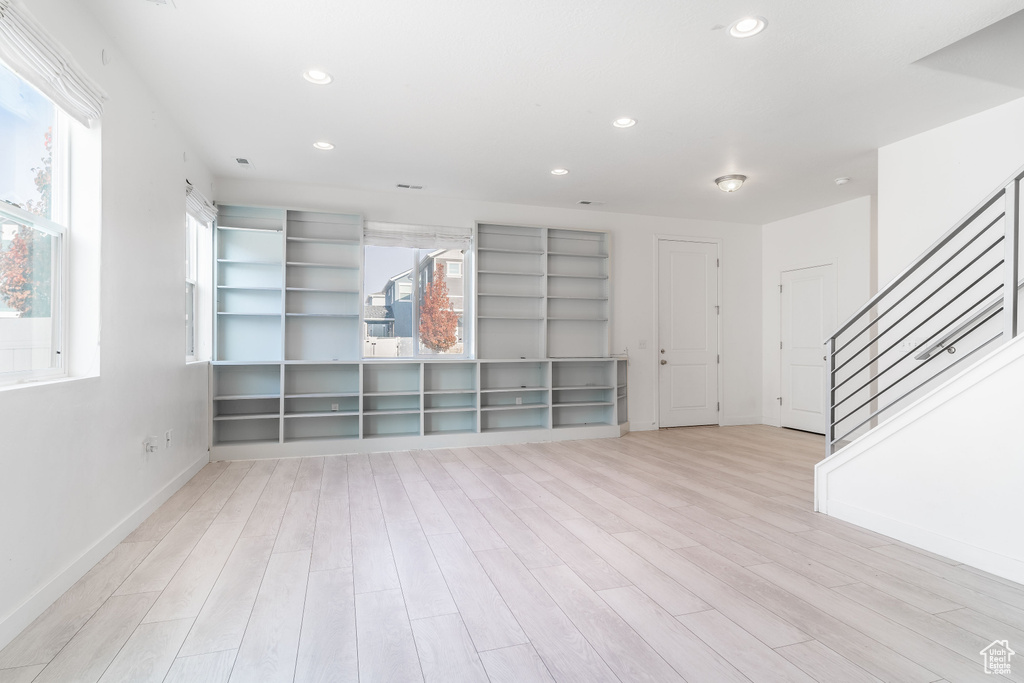 Unfurnished living room with light hardwood / wood-style flooring and a healthy amount of sunlight
