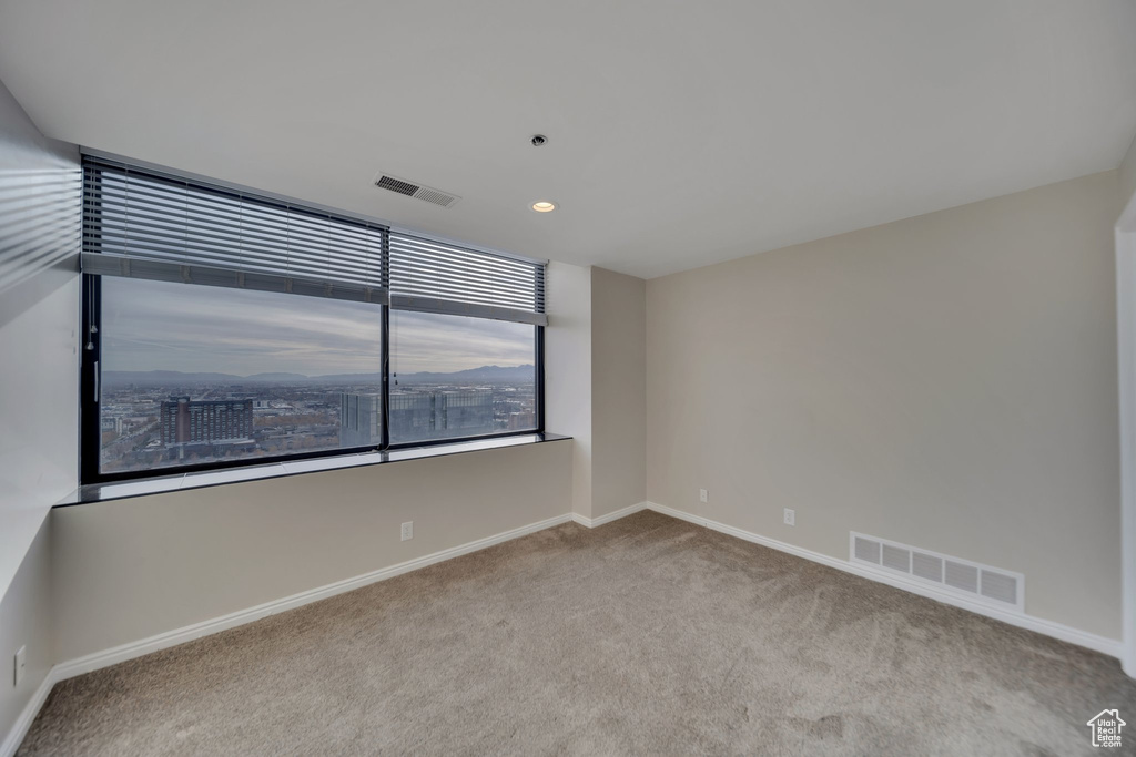 Empty room featuring light colored carpet