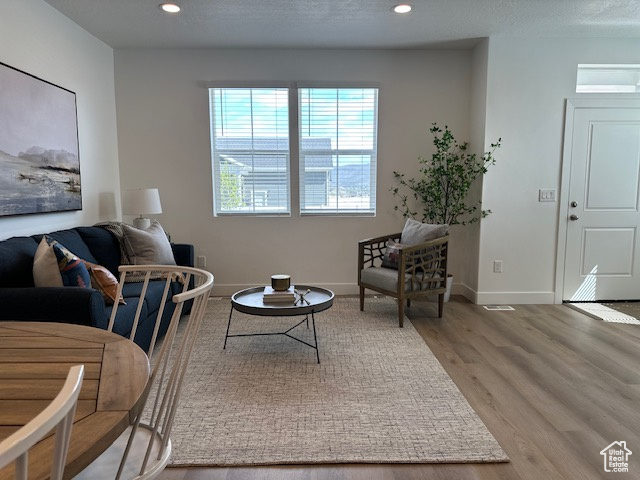 Living room featuring wood finished floors, recessed lighting, and baseboards