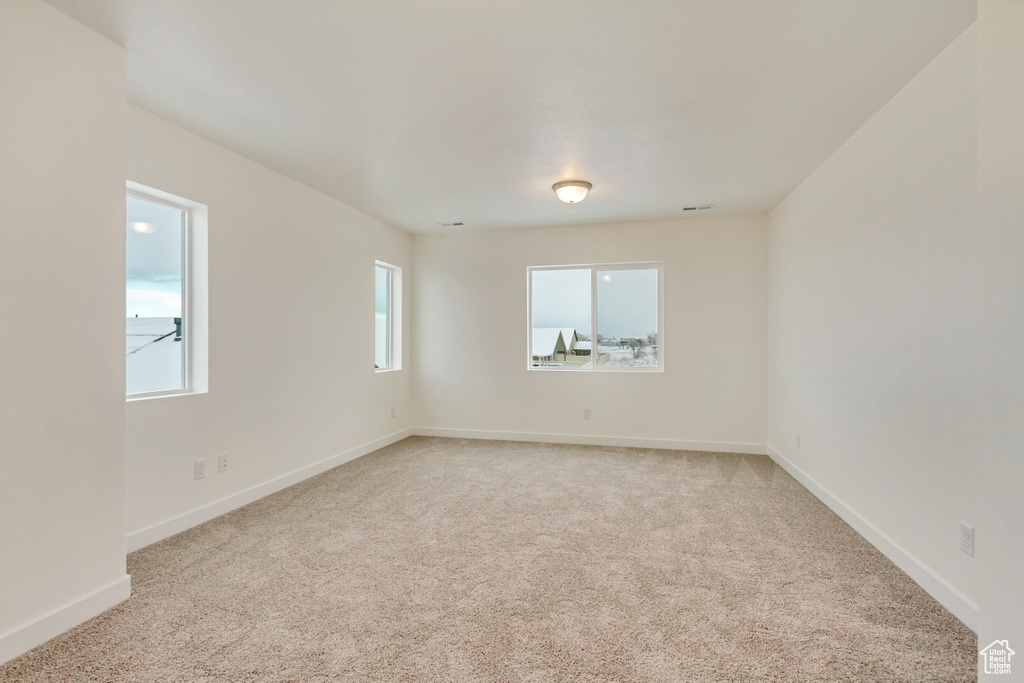 Empty room with light carpet and baseboards