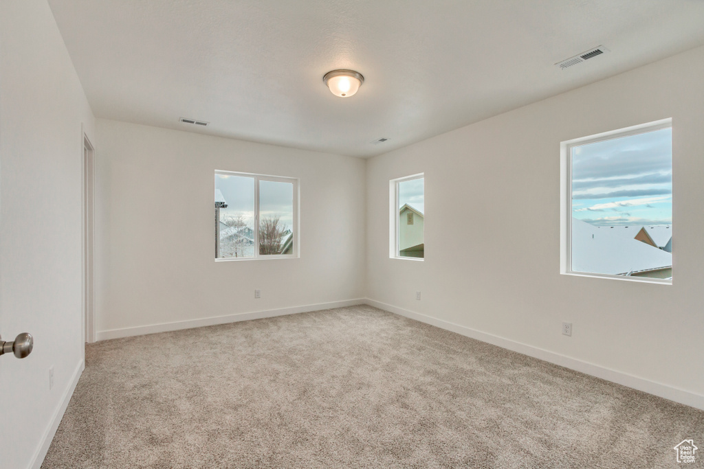 Spare room featuring carpet, baseboards, and visible vents