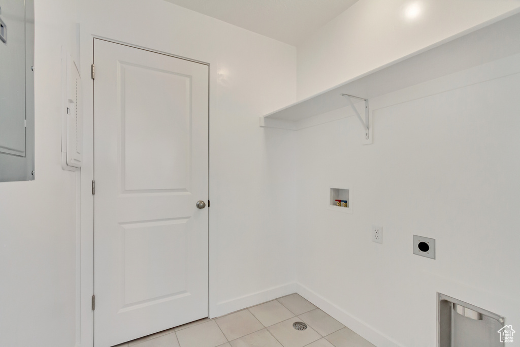 Laundry room with hookup for a washing machine, baseboards, laundry area, electric dryer hookup, and light tile patterned floors