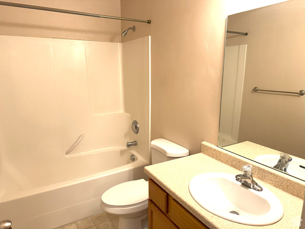 Full bathroom with tile patterned flooring, vanity, shower / bath combination, and toilet