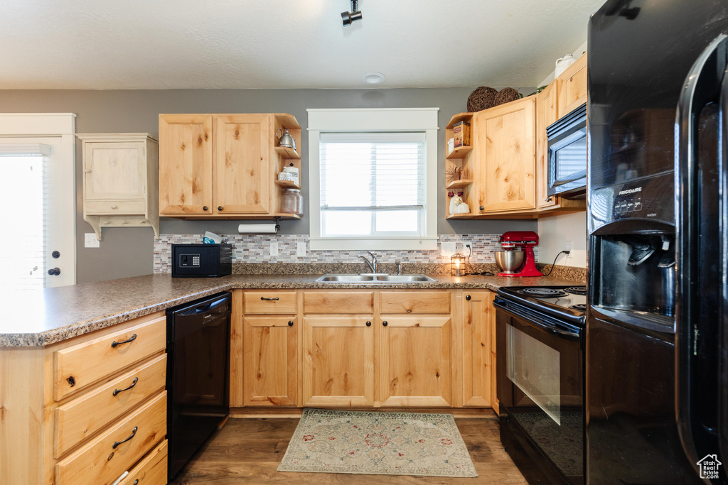 Kitchen with black appliances, open shelves, light brown cabinets, and a sink
