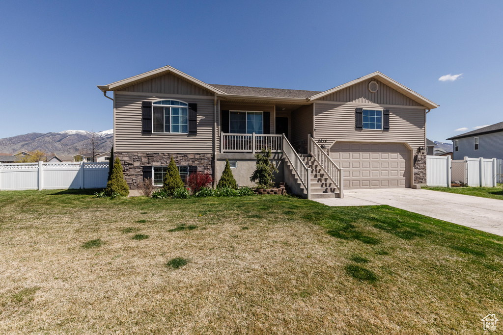 Ranch-style house featuring fence, a front yard, concrete driveway, and stairs