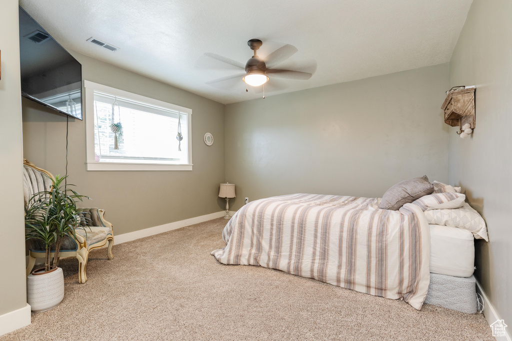 Carpeted bedroom featuring visible vents, ceiling fan, and baseboards