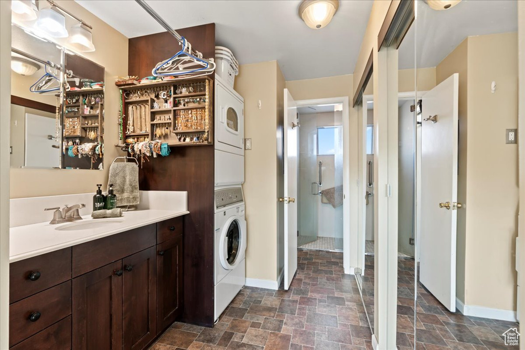 Washroom with stacked washer / drying machine and sink