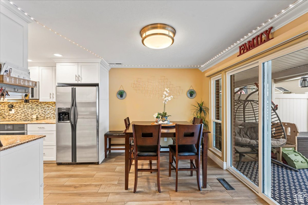 Dining room with light hardwood / wood-style floors and ornamental molding