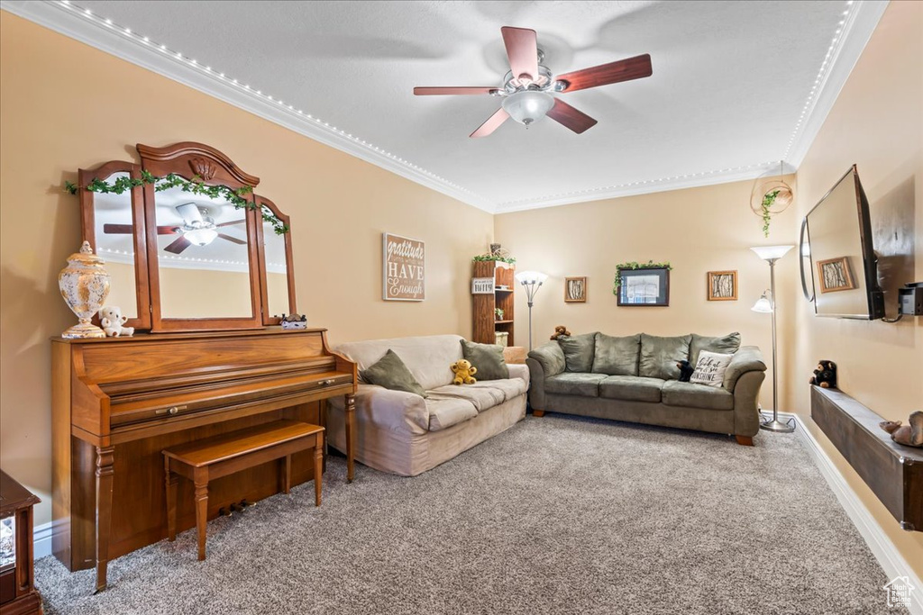 Carpeted living room with ceiling fan and ornamental molding