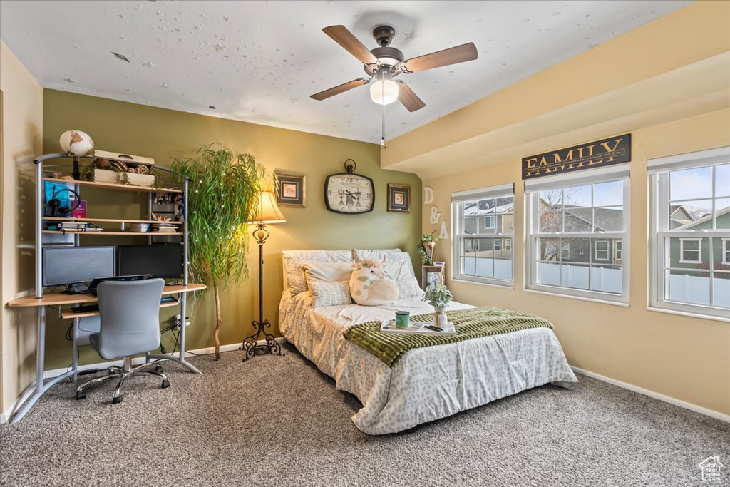 Carpeted bedroom featuring ceiling fan