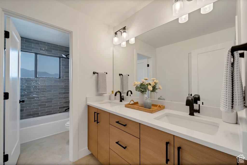Full bathroom with tiled shower / bath, vanity, and toilet