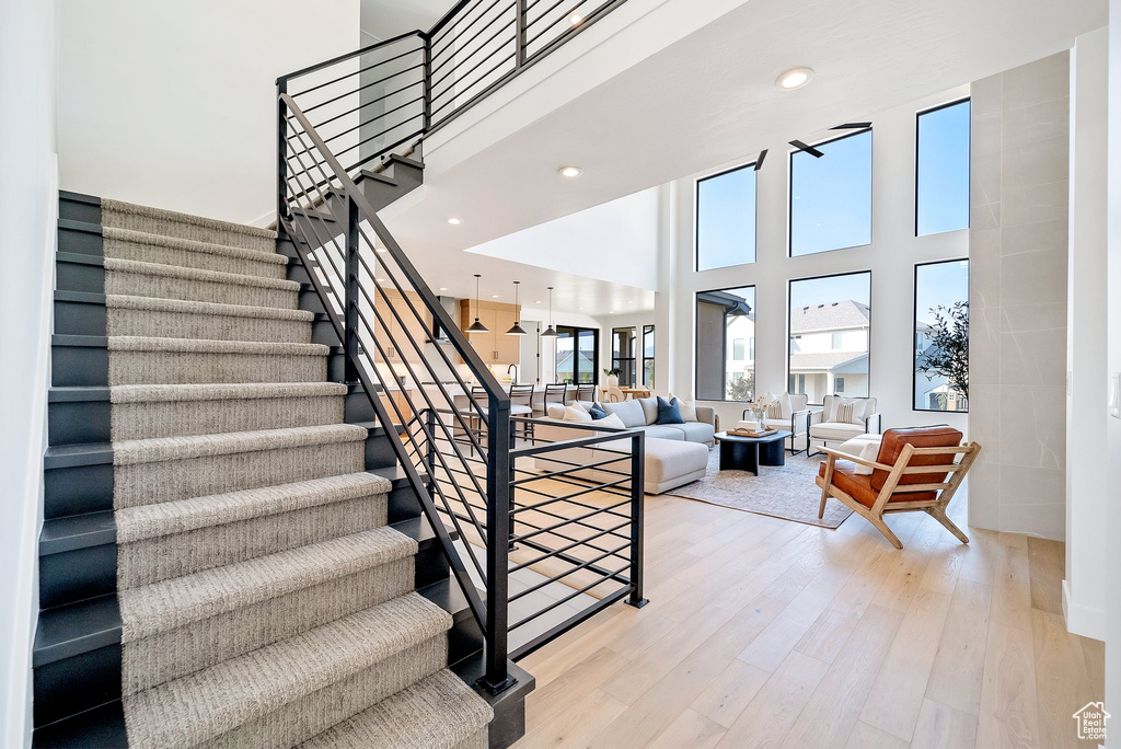 Stairway with a high ceiling and hardwood / wood-style floors