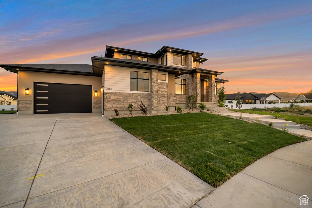 Prairie-style home featuring a lawn and a garage