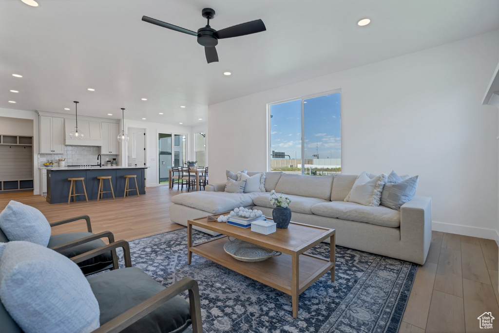 Living room featuring ceiling fan, light hardwood / wood-style flooring, and sink