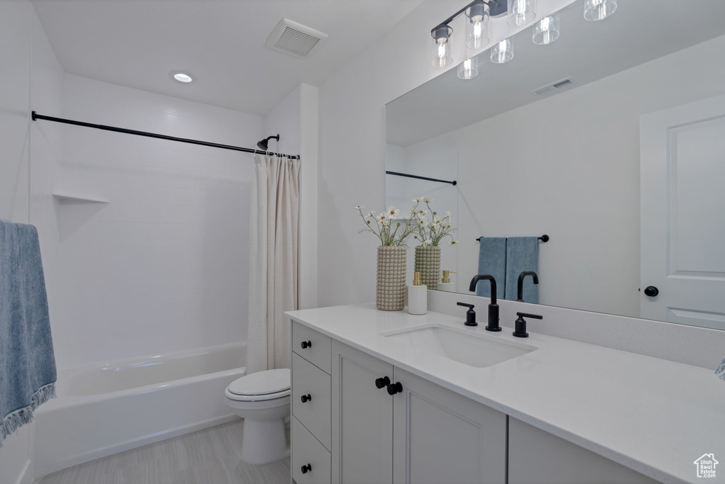 Full bathroom with vanity, toilet, and shower / bathtub combination with curtain