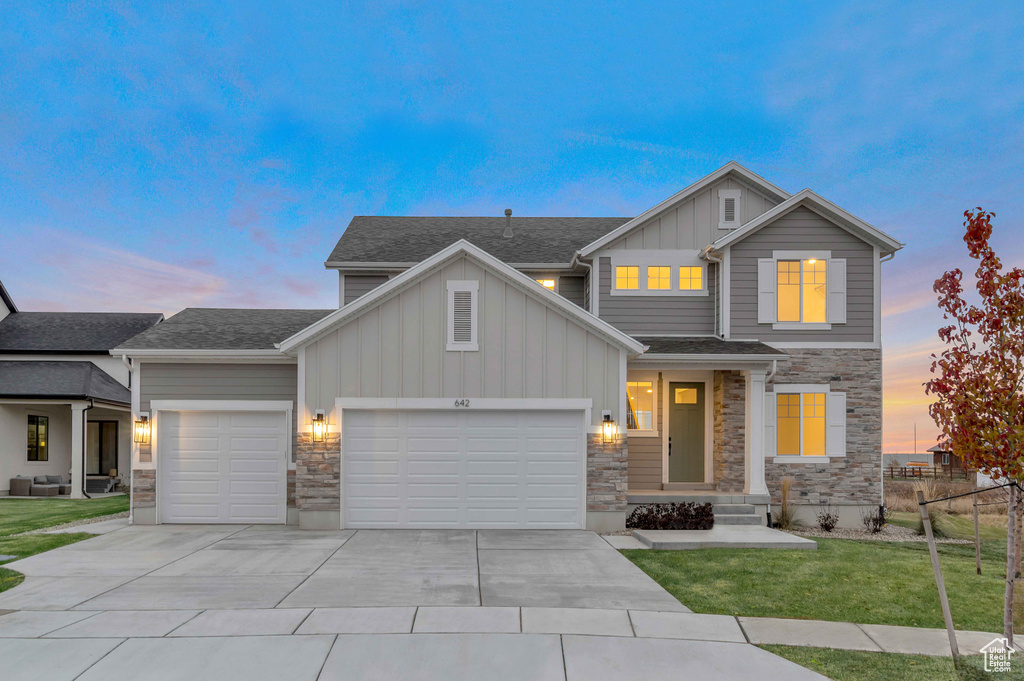 Craftsman-style house featuring a yard and a garage