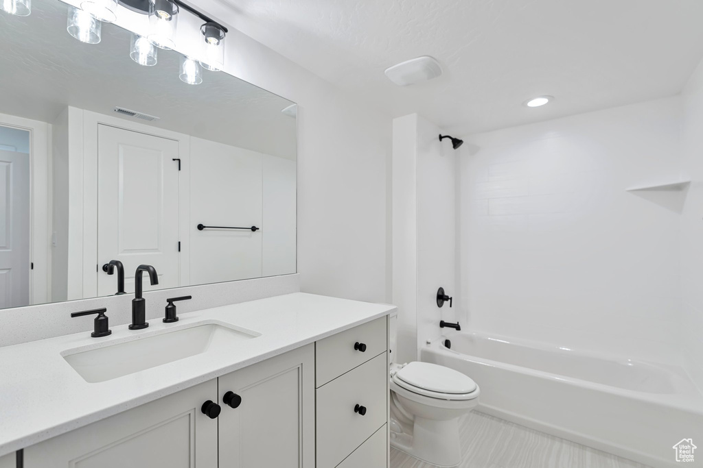 Full bathroom featuring toilet, vanity, and bathing tub / shower combination