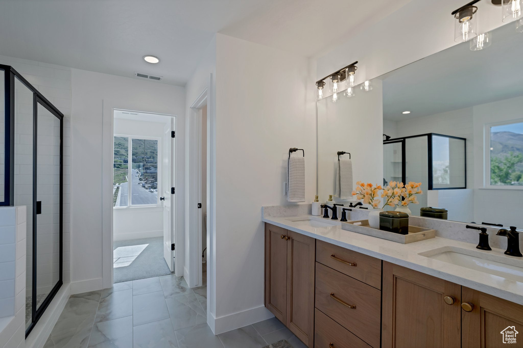 Bathroom with plenty of natural light, vanity, and a shower with shower door