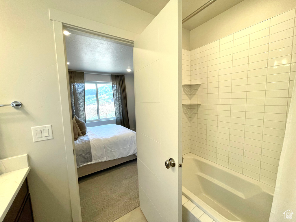 Ensuite bathroom featuring vanity and shower / washtub combination