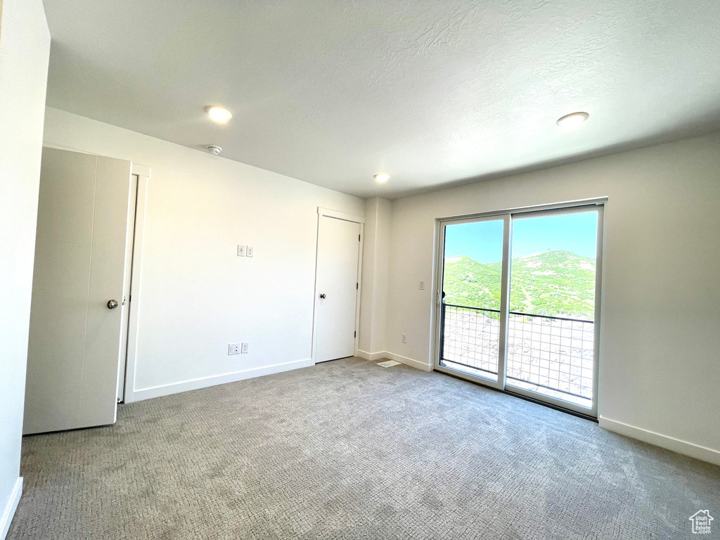 Carpeted spare room featuring a textured ceiling and recessed lighting