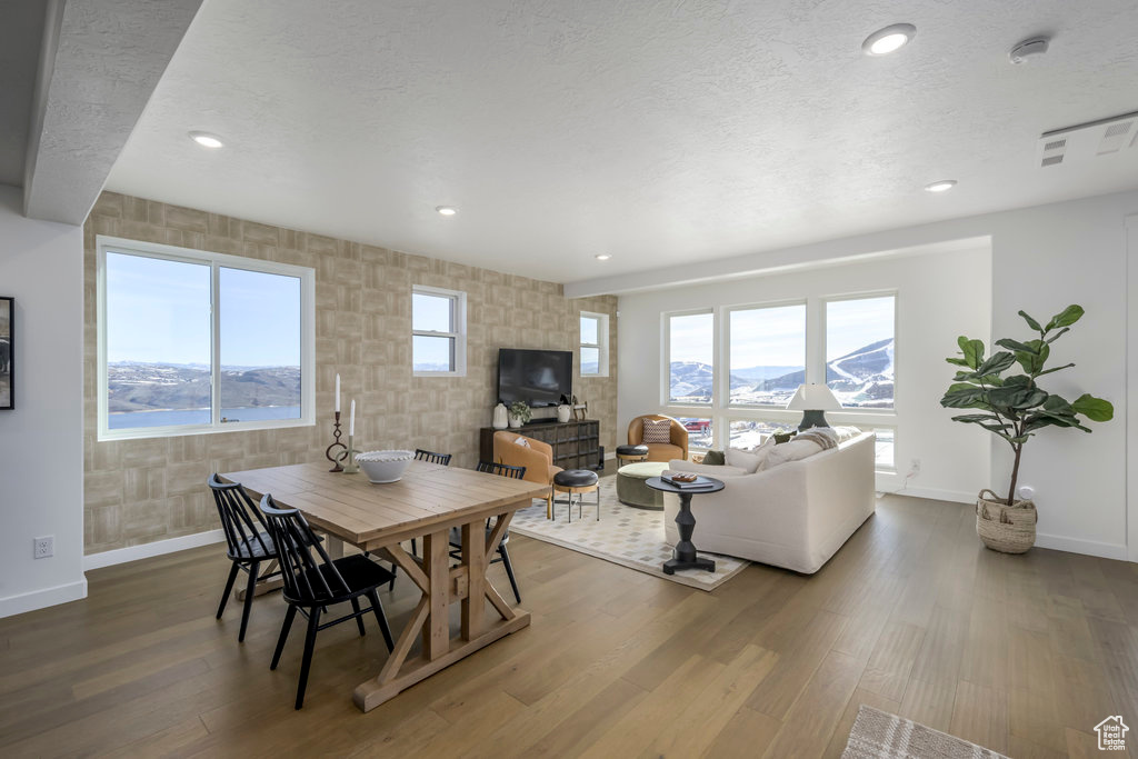 Dining space featuring baseboards, a textured ceiling, and an accent wall