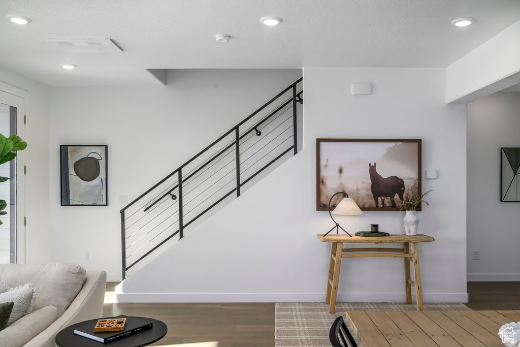 Stairs with baseboards, recessed lighting, wood finished floors, and visible vents