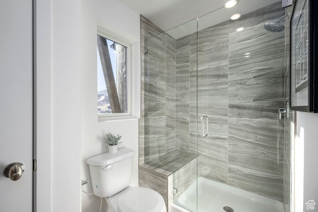 Bathroom featuring a stall shower and toilet