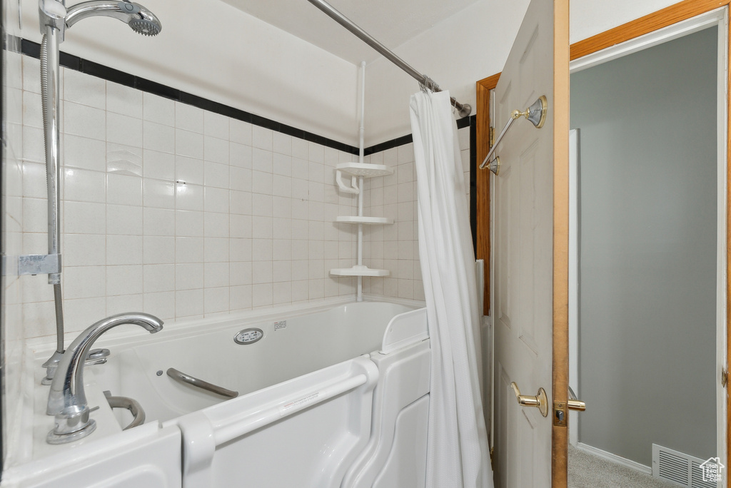 Bathroom with shower / bathtub combination with curtain