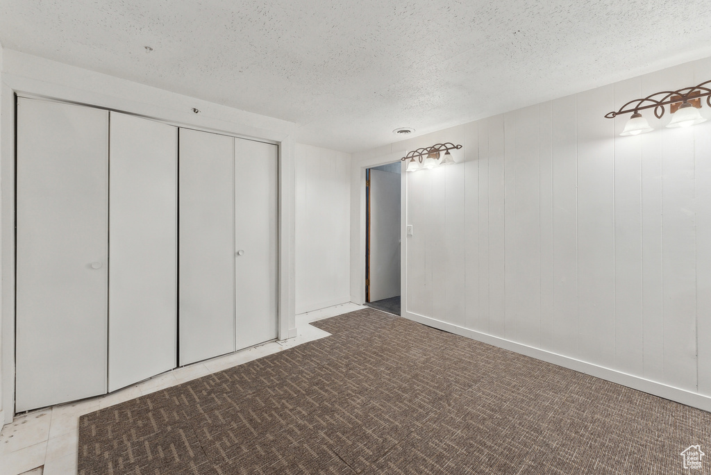 Unfurnished bedroom featuring a textured ceiling and a closet