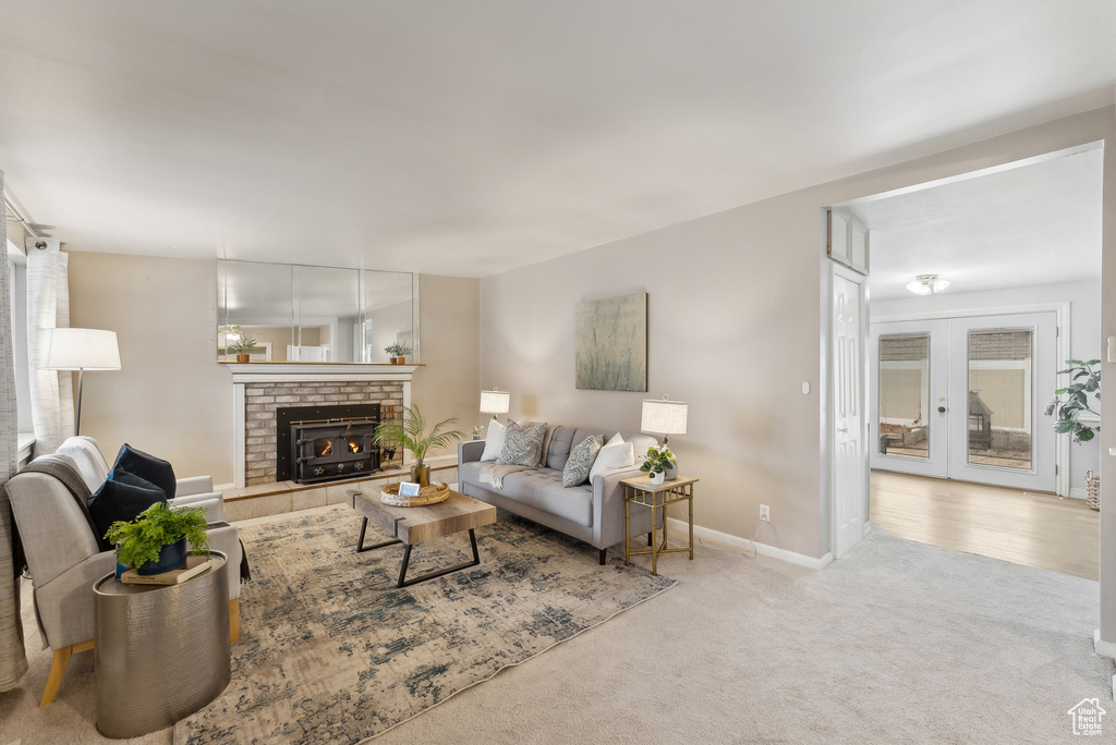 Carpeted living room featuring french doors and a brick fireplace