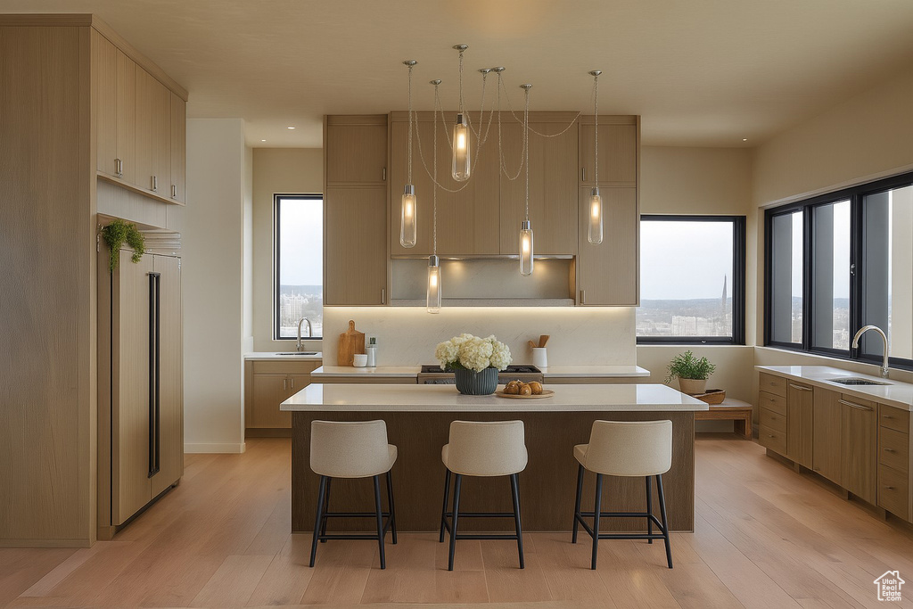 Kitchen with a center island, light countertops, light wood-type flooring, a breakfast bar area, and recessed lighting