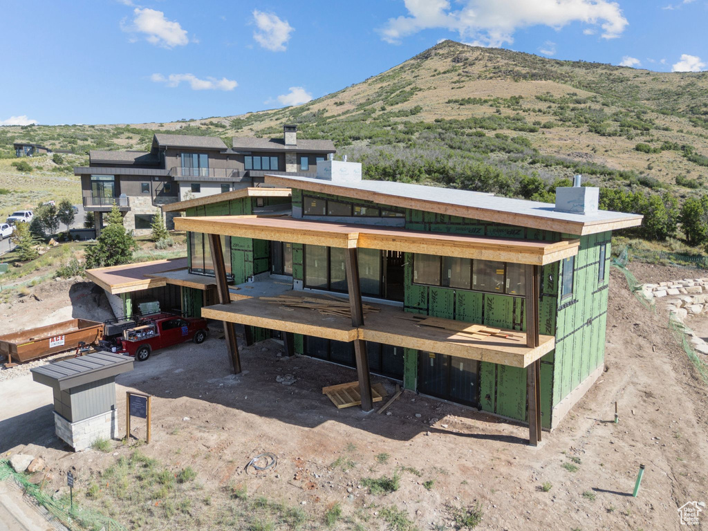 Rear view of house featuring a chimney and a deck with mountain view