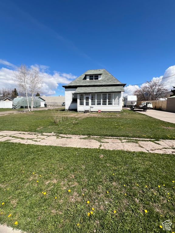 View of front of property with fence and a front yard