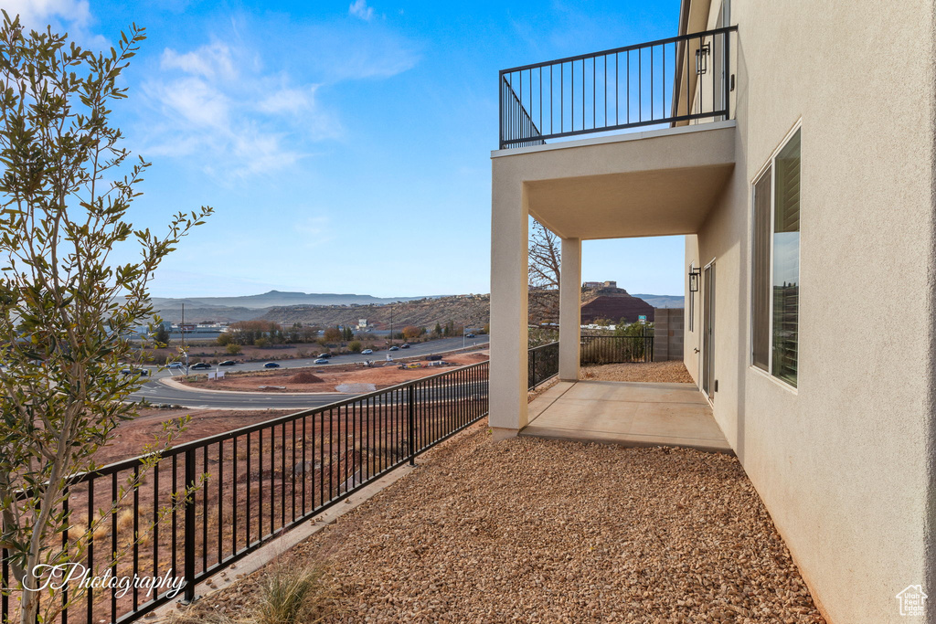 View of yard with a mountain view, a balcony, and a patio