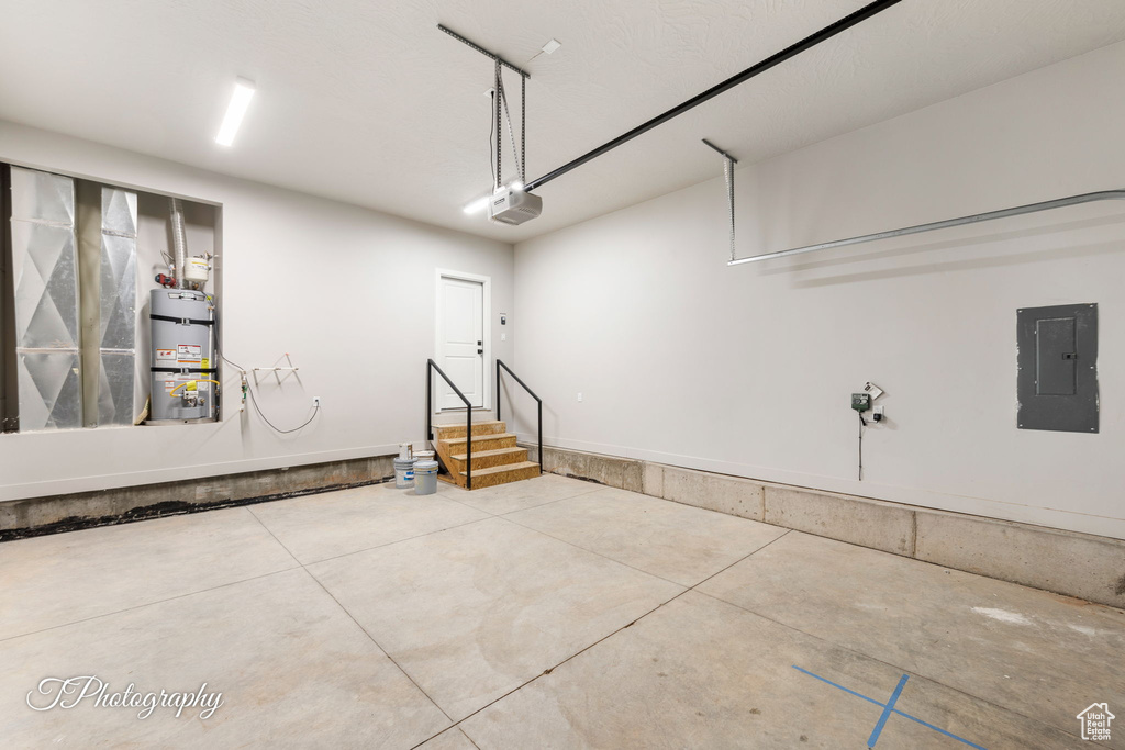 Garage with electric panel, water heater, and a garage door opener