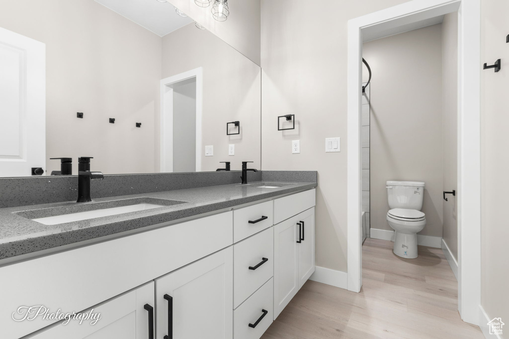 Bathroom featuring hardwood / wood-style floors, vanity, and toilet