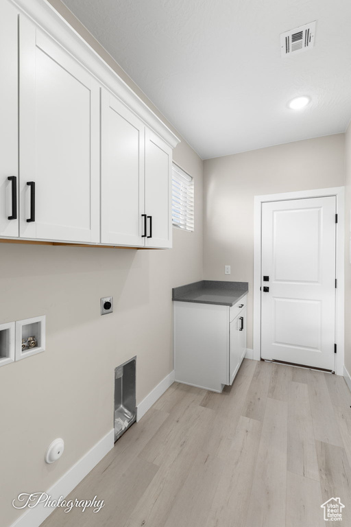 Laundry area with washer hookup, electric dryer hookup, cabinets, and light wood-type flooring