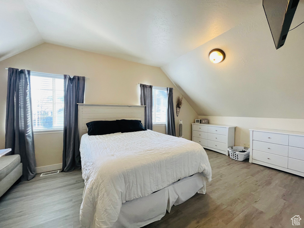 Bedroom featuring light hardwood / wood-style floors and vaulted ceiling